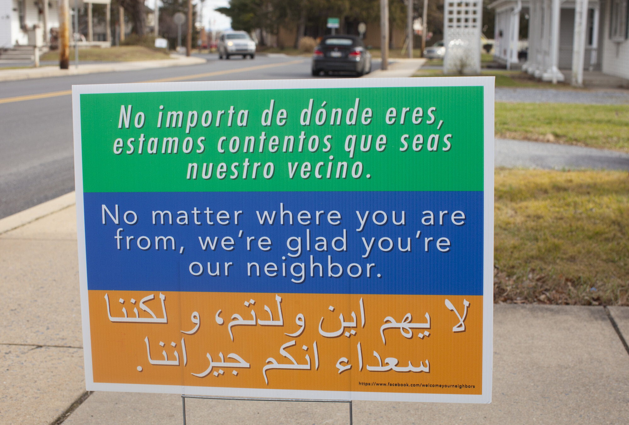 A sign reads "No matter where you are from, we are glad you are our neighbor"