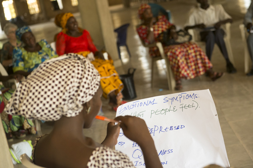 Naomi Philip looks at a list of emotional symptoms during a Healing and Reconciling our Communities (HROC) trauma healing workshop at Nigeria Church of the Brethren (EYN) headquarters in Mubi, Nigeria