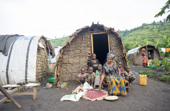 Nsimire Mugoli sits at the family hut with her younger children she will feed with the food she received from the emergency food distribution she received earlier in the day.
At Mubimbi camp near the