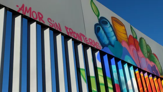 Colorful graffiti on a tall border wall