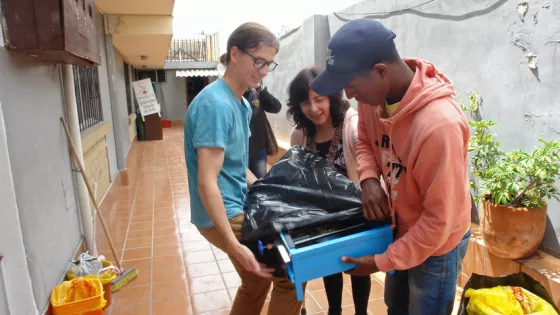 Kiernan Wright of Orrville, Ohio (left), who served in Quito, Ecuador through MCC's Serving and Learning Together (SALT) program in 2017/2018, helps a refugee family pack the stove they received. (The