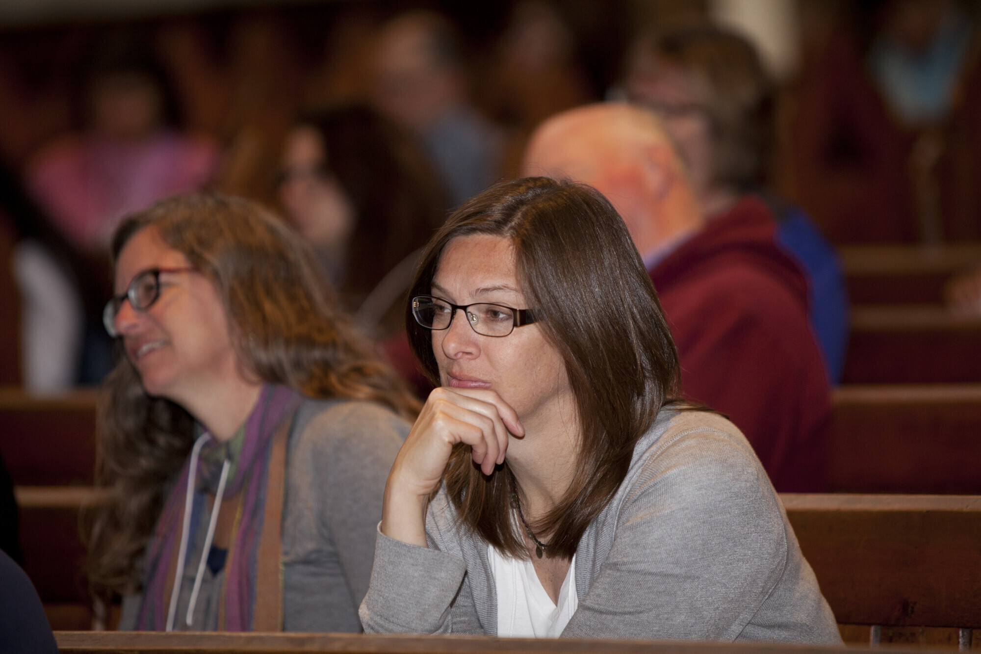 A woman listening to a someone speaking at an event