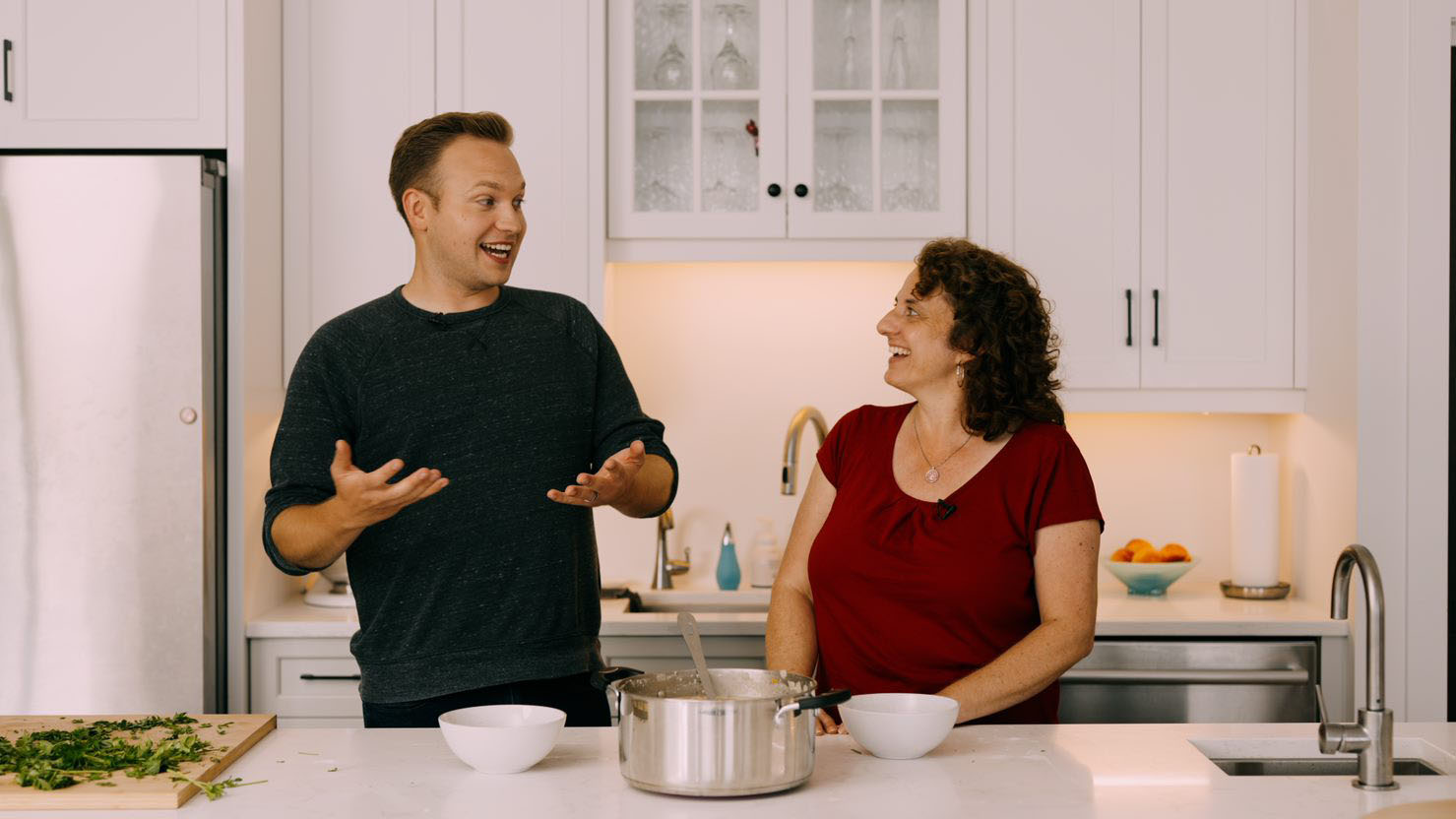 A man and a woman laughing together in a kitchen