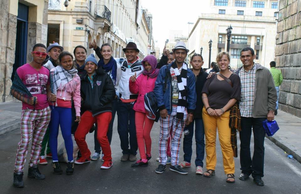 A group of people with different coloured pants standing in a street in Bogota