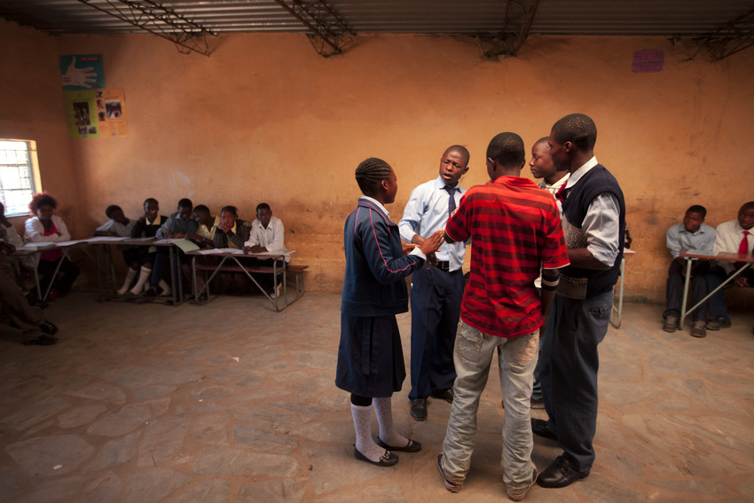 Students Christoph Iback Mbewe, red shirt, and Richard Tande, wearing tie, perform a skit to show the need for peacemaking during peace club at Mancilla Open Community School in Lusaka, Zambia.  They